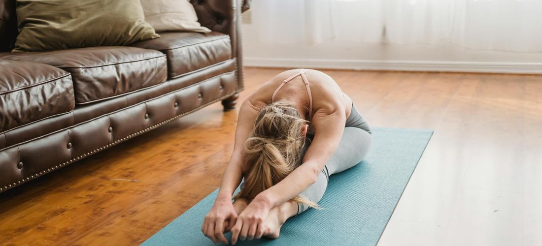 A cozy and calm corner of a room with a yoga mat rolled out, ready for practice.