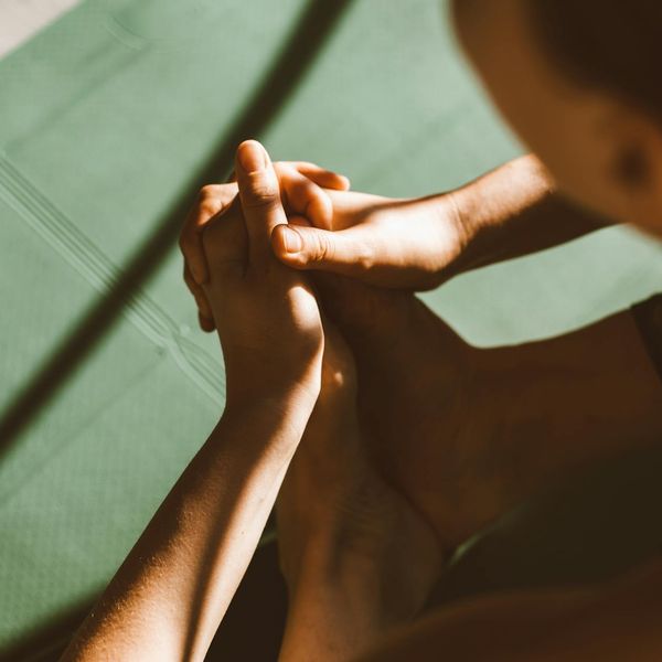 Close-up of hands in a meditative gesture during a yoga practice.