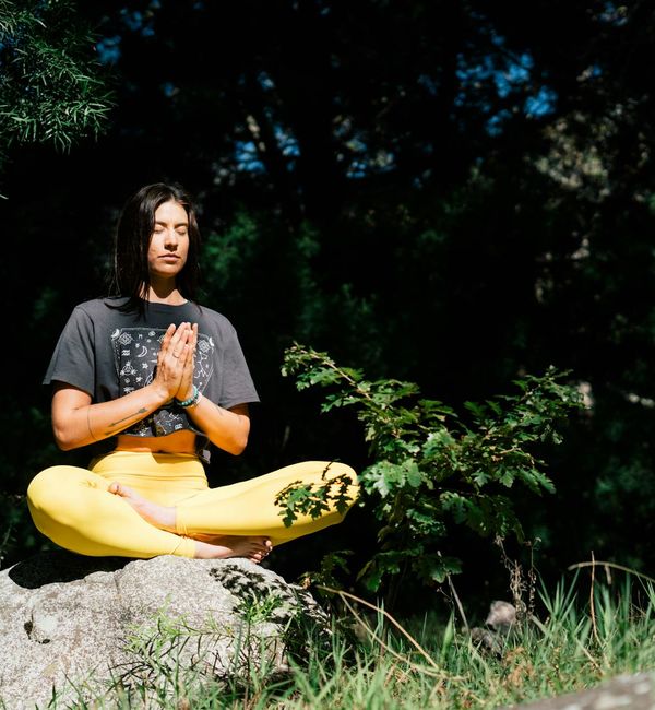 Woman balancing in a tree yoga pose with a serene expression.